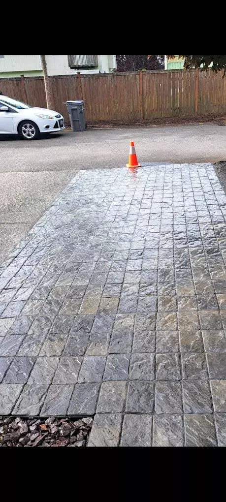 Freshly installed stone paver driveway with a traffic cone at the edge.